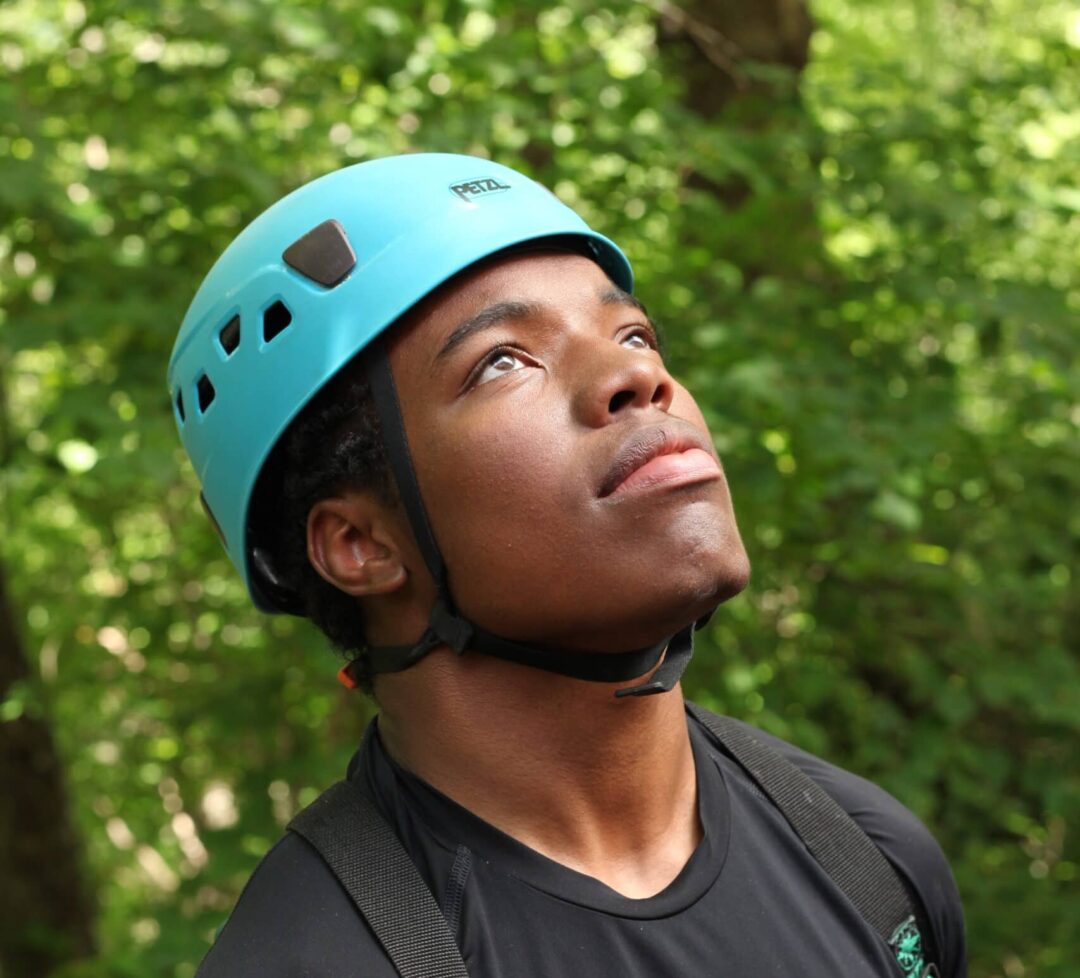 Young man looks skyward while rock climbing