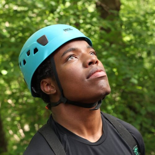 Young man looks skyward while rock climbing